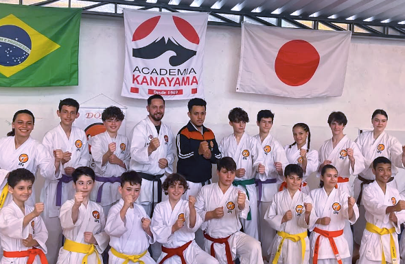 Alunos de Karate sorrindo em pose de fim de treino, mostrando união.
